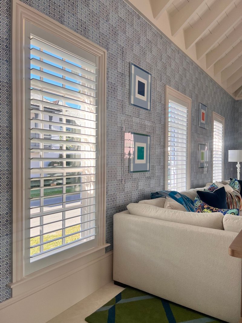 Bedroom corner with a textured grey grasscloth-style wallcovering by the window