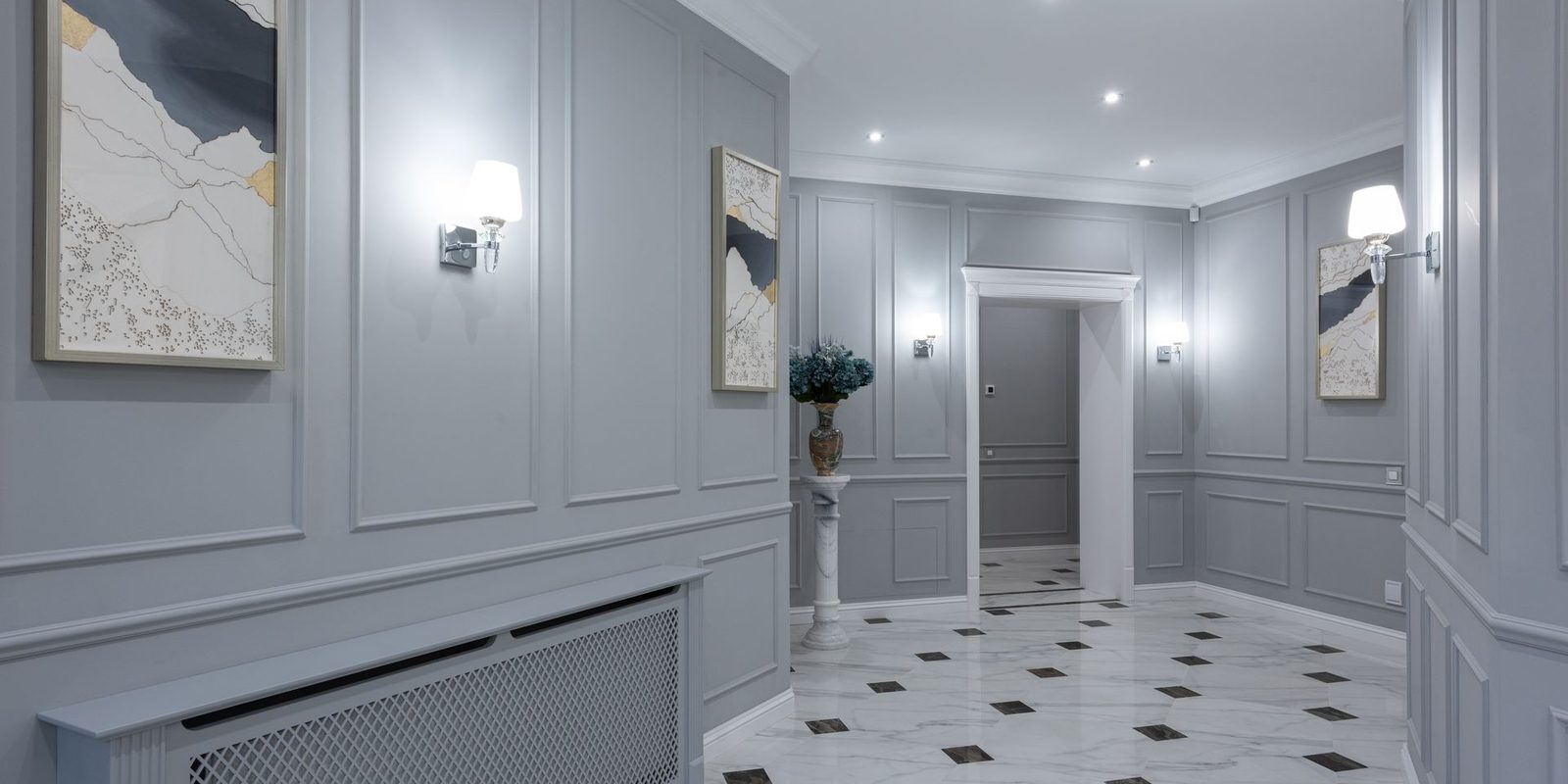Refined grey panelled hallway with framed art and a patterned marble floor